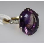 An 18ct gold and amethyst dress ring with diamond set shoulders, size K.