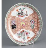 A Chinese famille rose dish, 19th century, Yongzheng mark, painted to shaped reserves with
