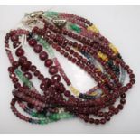 An Indian double strand facetted ruby bead necklace, a similar bracelet and a multi gem set triple