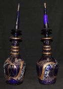 A pair of gilded and enamelled blue glass decanters and stoppers
