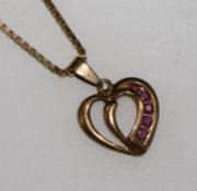 A 9ct gold and ruby set heart pendant on a 9ct gold chain.
