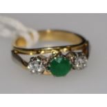 A gold and three stone emerald and diamond ring, size G.