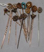A collection of fourteen assorted gold and gem set stick pins.