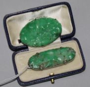 Two white metal mounted carved jadeite brooches.