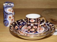 A Royal Crown Derby paperweight, a cup and three saucers