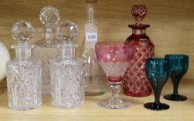 A ruby overlaid glass decanter, four other decanters and three glasses