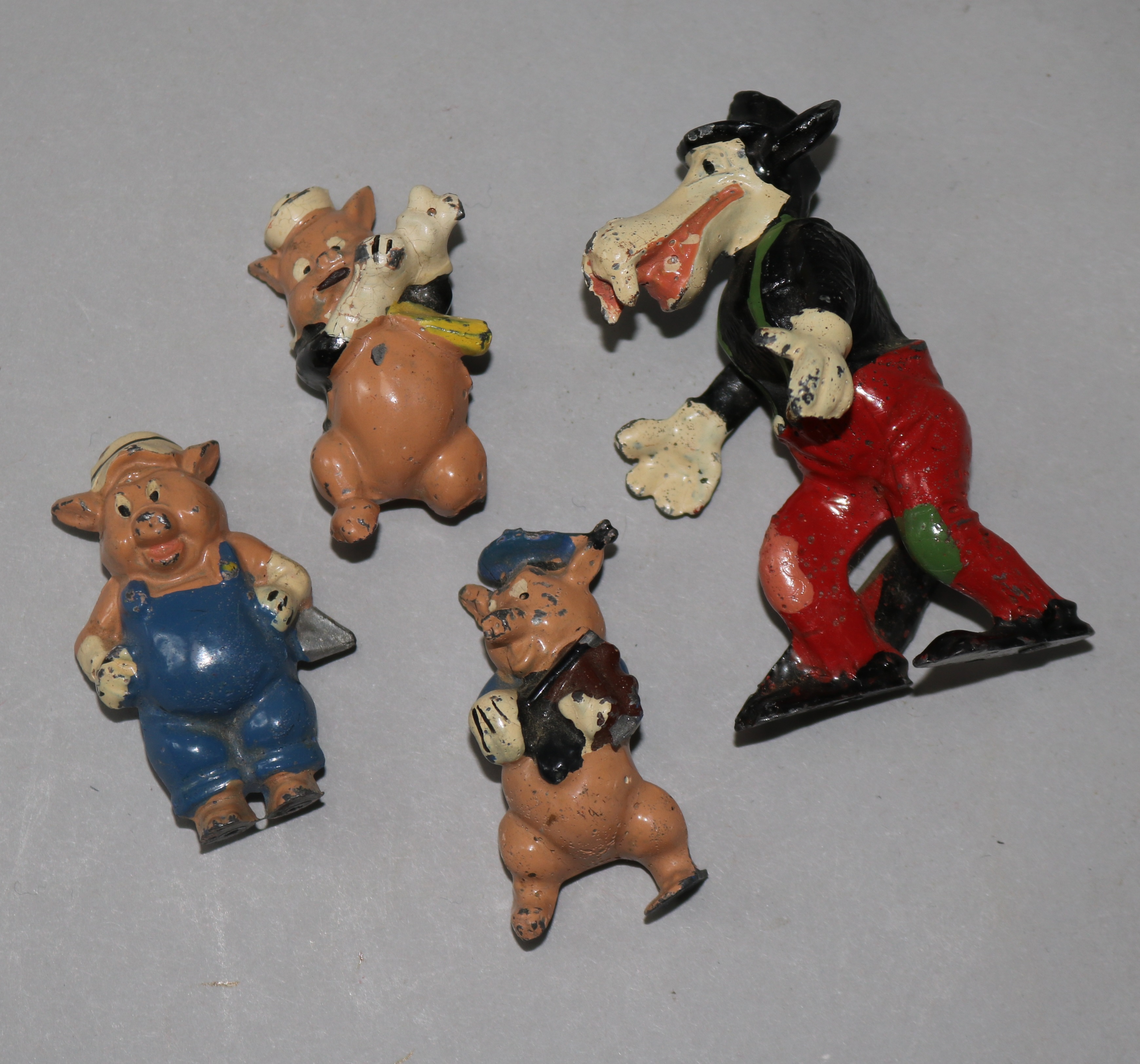 Four Disney pre-war hollow cast figures, Three Little Pigs and the Big Bad Wolf (damage and