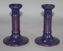 A pair of Moorcroft purple lustre candlesticks, 6in.