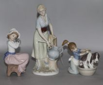 A Lladro figure of a girl washing a dog and two other figures