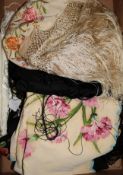 A black multi-coloured shawl, a cream embroidered shawl, another and a black lace stole