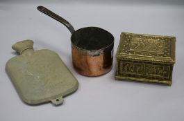 An early child's hot water bottle cover, saucepan and brass box