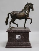 A bronze equestrian figure on a porphyry style pedestal