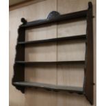 An Edwardian carved oak four shelf wall bracket, W.100cm