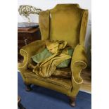 A Georgian style wing back armchair with gold upholstery