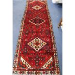 A Hamadan red ground rug, 288cm x 96cm