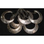 A set of six white metal crescent shaped wine labels.