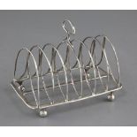 A George III silver seven bar toast rack by Thomas Lamborn, on ball feet, Sheffield, 1803?, 16.