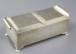 A stylish George V silver double lidded cigarette box, the engine turned lids with scroll handles,