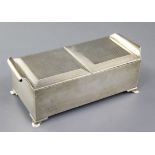 A stylish George V silver double lidded cigarette box, the engine turned lids with scroll handles,