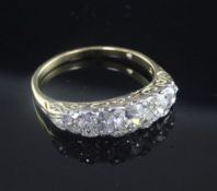 An 18ct gold and graduated five stone diamond half hoop ring, size T.