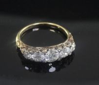 An early 20th century 18ct gold and graduated five stone diamond half hoop ring, set with old cut