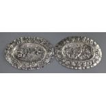 A pair of late 18th century Augsburg small silver oval plaques, embossed with cherubs, masks and