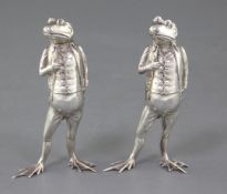 A pair of modern novelty silver pepperettes modelled as a pair of free standing frogs dressed in