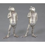 A pair of modern novelty silver pepperettes modelled as a pair of free standing frogs dressed in