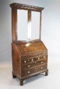 An early 18th century walnut bureau bookcase, with two glazed doors over a fall enclosing a well,