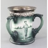 A Lenox Ceramic Art Company golf three handled mug, c.1905, signed W. Clayton, painted in green