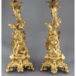 A pair of 19th century French ormolu lamp bases, modelled with foliate scrolls and seated youths,