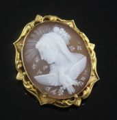 A yellow metal mounted oval cameo brooch, carved with the bust of a lady to dexter, with a bird in
