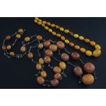 Two single strand amber bead necklaces, one with twenty nine graduated beads with chain links, the