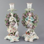 A pair of Derby candlestick figures, c.1770, modelled as a lady holding flowers in her apron and a