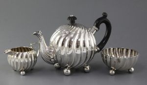 A late Victorian spiral fluted globular three piece tea set by Moritz & Simon Lothiem, on ball feet,