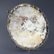 A George III silver shaped circular salver, with later engraved initials and gadrooned border, on