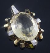 A 1940's/1950's 18ct gold mounted citrine and diamond set oval pendant, with scrolling border, 5cm.