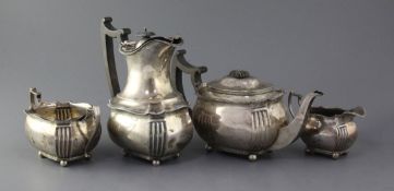 An Edwardian silver four piece tea set by Edward Barnard & Sons, of oval form with fluted angles,