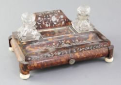 An early Victorian mother of pearl inset tortoiseshell ink stand, with two cut glass wells and