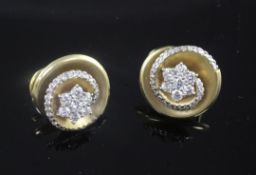 A pair of 18ct gold and diamond set circular earrings, of whorl design with central flower head
