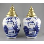 A near pair of Dutch delft blue and white tobacco jars and brass covers, late 18th century, the