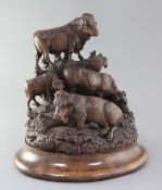A late 19th century Black Forest carved wood group of a bull, two cows and a calf upon a mountain