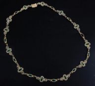 An early 19th century gold, green paste and seed pearl set spectacle necklace, (a.f.), 15.75in.
