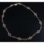 An early 19th century gold, green paste and seed pearl set spectacle necklace, (a.f.), 15.75in.