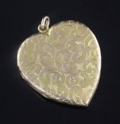 An engraved yellow metal heart shaped pendant locket, with floral scroll decoration, 47mm.