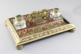 A 19th century French red boulle work double inkstand, with central handle and two cut glass