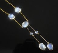 An Edwardian 9ct gold and moonstone drop necklace, set with seven oval cabochons, 16in.