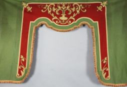 A pair of French green and red baize window lambrequins, late 19th century, with applique-work urn