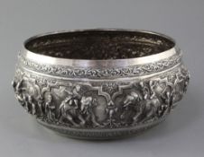 A late 19th century Burmese silver bowl, embossed with continuous scene of figures and animals at