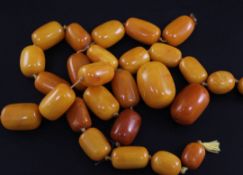 Twenty seven graduated amber beads, some strung, gross weight 188 grams.
